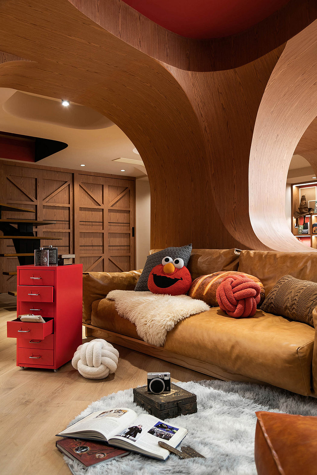 Wooden arches, built-in shelves, and a cozy, eclectic living space with Elmo plush toy.