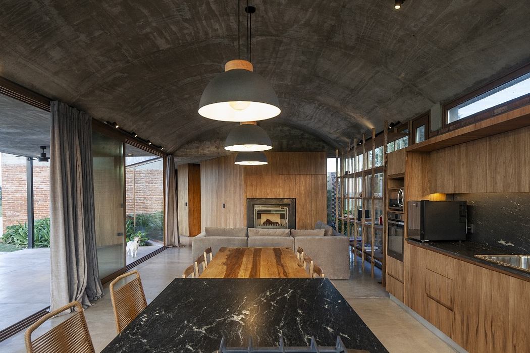 Spacious open-plan interior with concrete ceiling, wooden furnishings, and large glass windows.