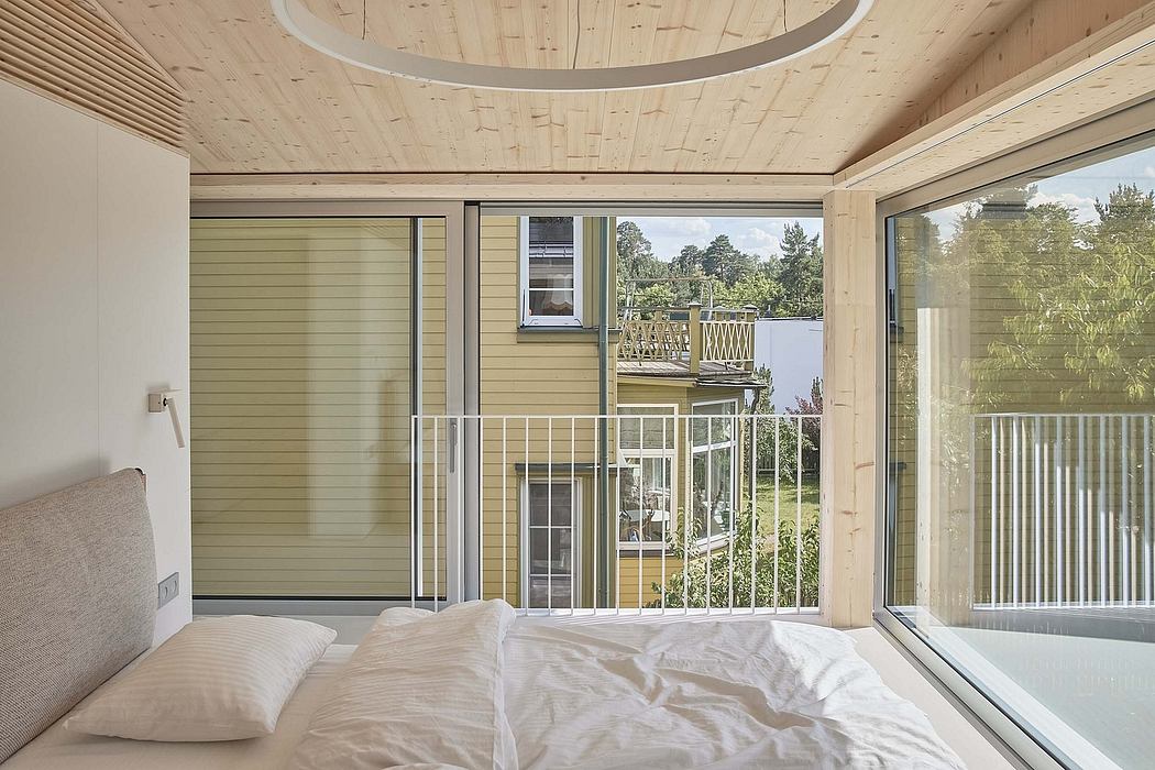 Spacious modern bedroom with wood-paneled ceiling, large windows, and glass sliding doors.