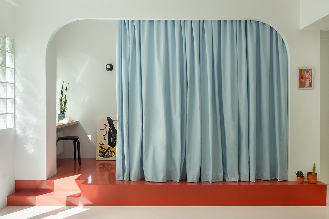 Curved arched entryway, long curtains, stepped platform, artwork, and potted plants in modern, minimalist interior.