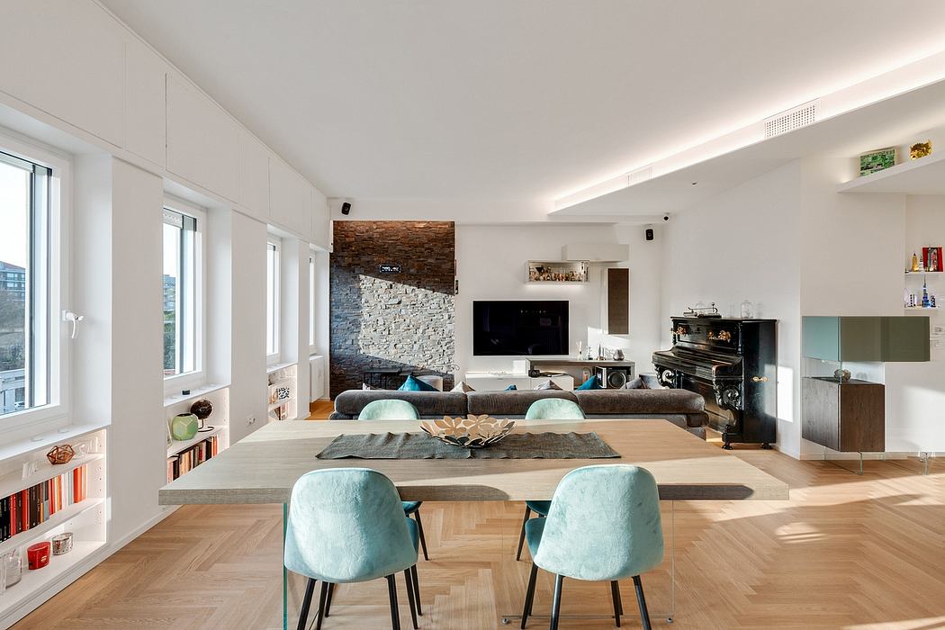 Spacious, modern living room with large windows, exposed brick wall, and wood flooring.