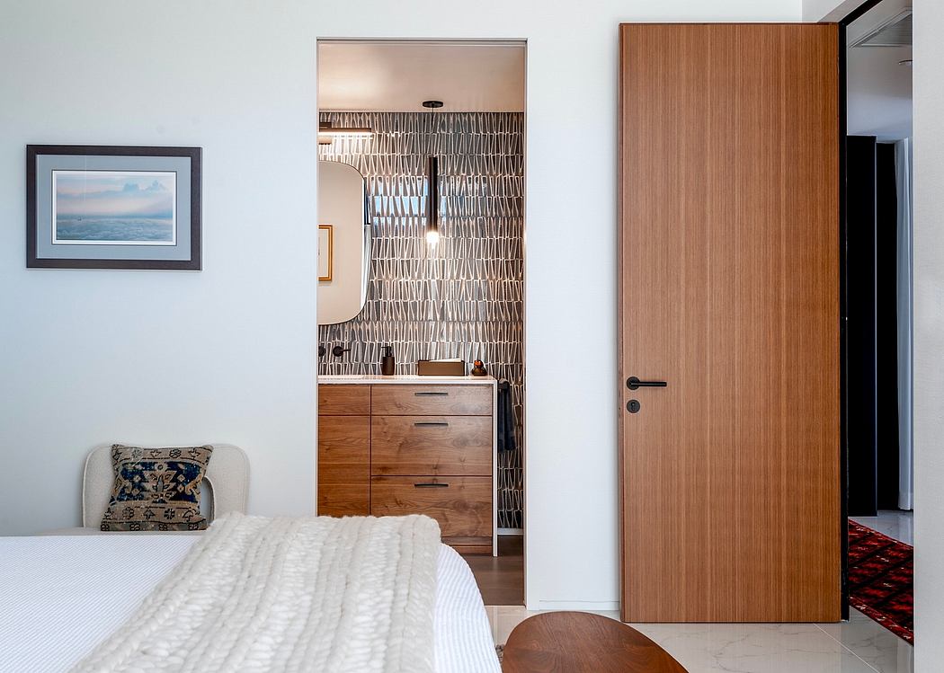 Cozy bedroom with wooden dresser, patterned wallpaper, and modern wooden door.