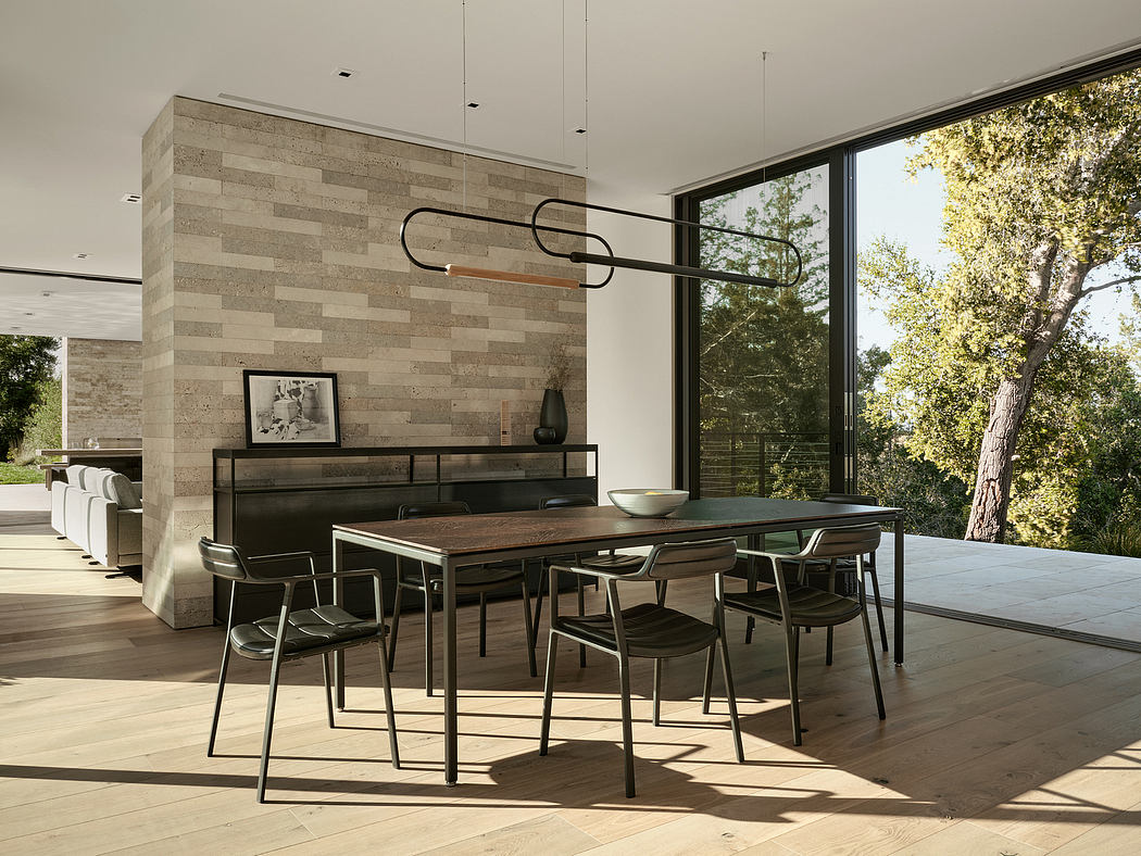 Sleek, modern dining area with stone accent wall, floor-to-ceiling windows, and minimalist furnishings.