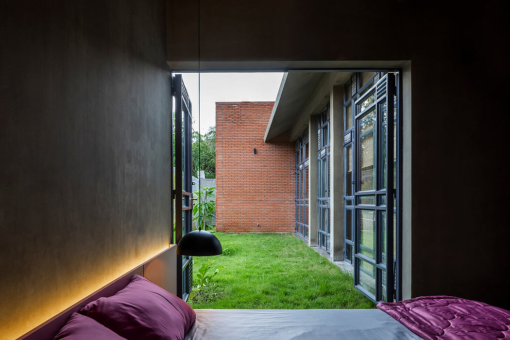Interior with modern brick facade, glass doors, lush lawn, and plush purple furnishings.