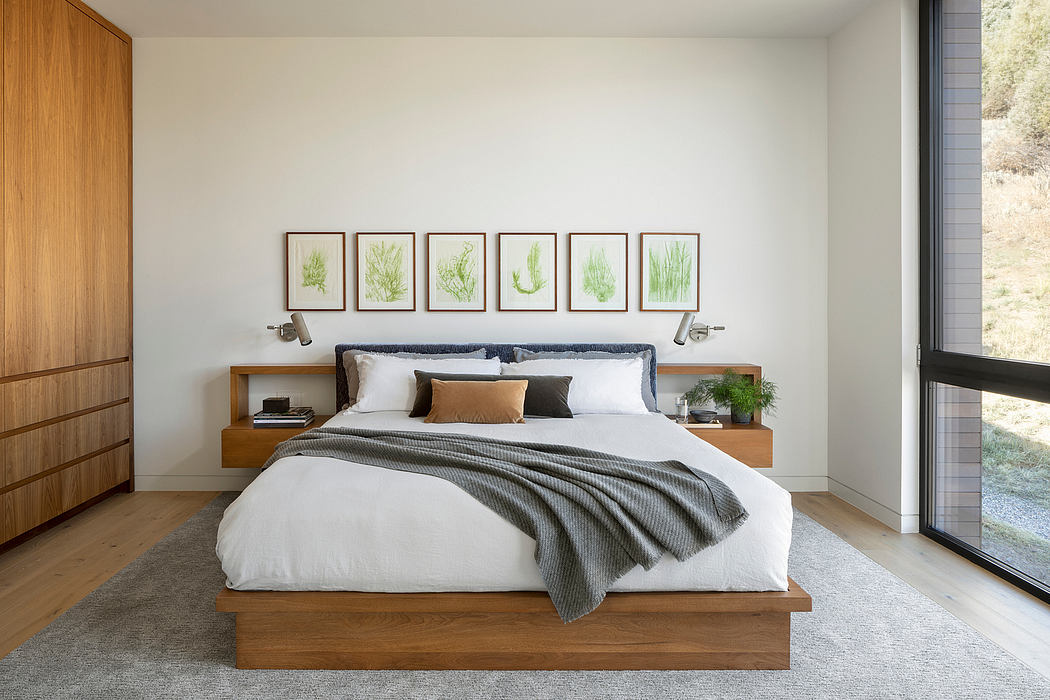 Minimalist bedroom design with wood furniture, nature-inspired art, and large window.