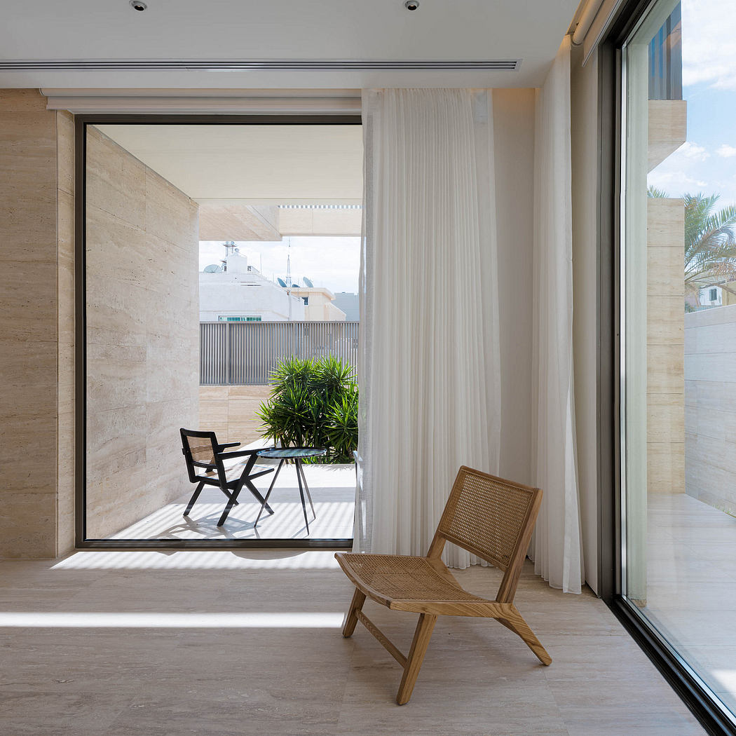 Minimalist interior with natural stone walls, curtains, and wooden furniture on balcony.
