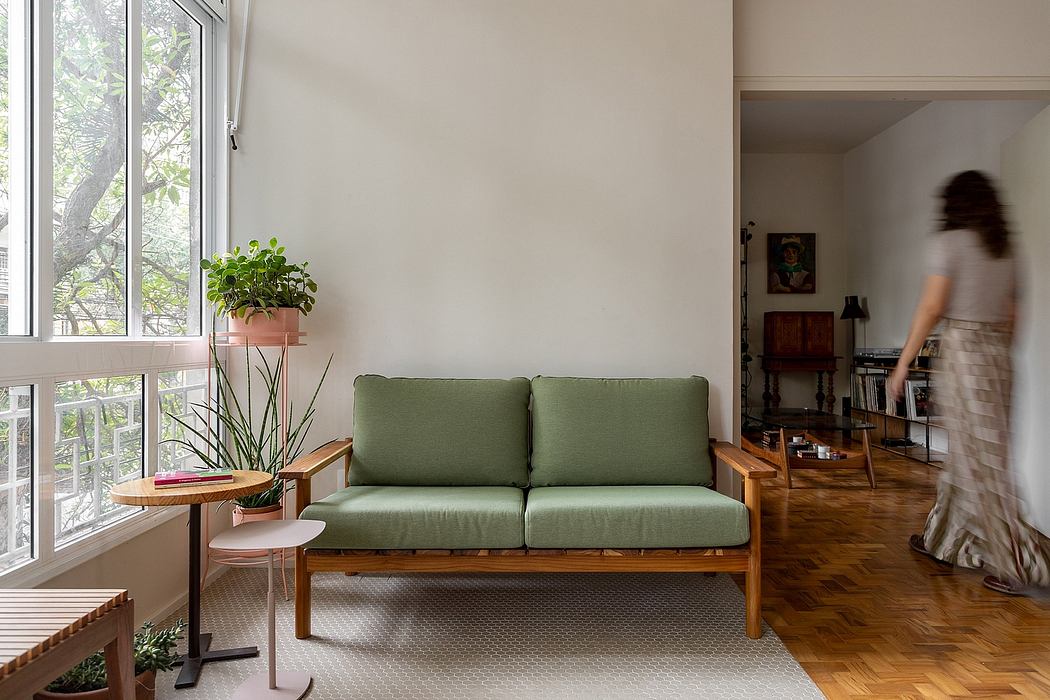 Minimalist living room with wooden sofa, potted plant, and parquet flooring.