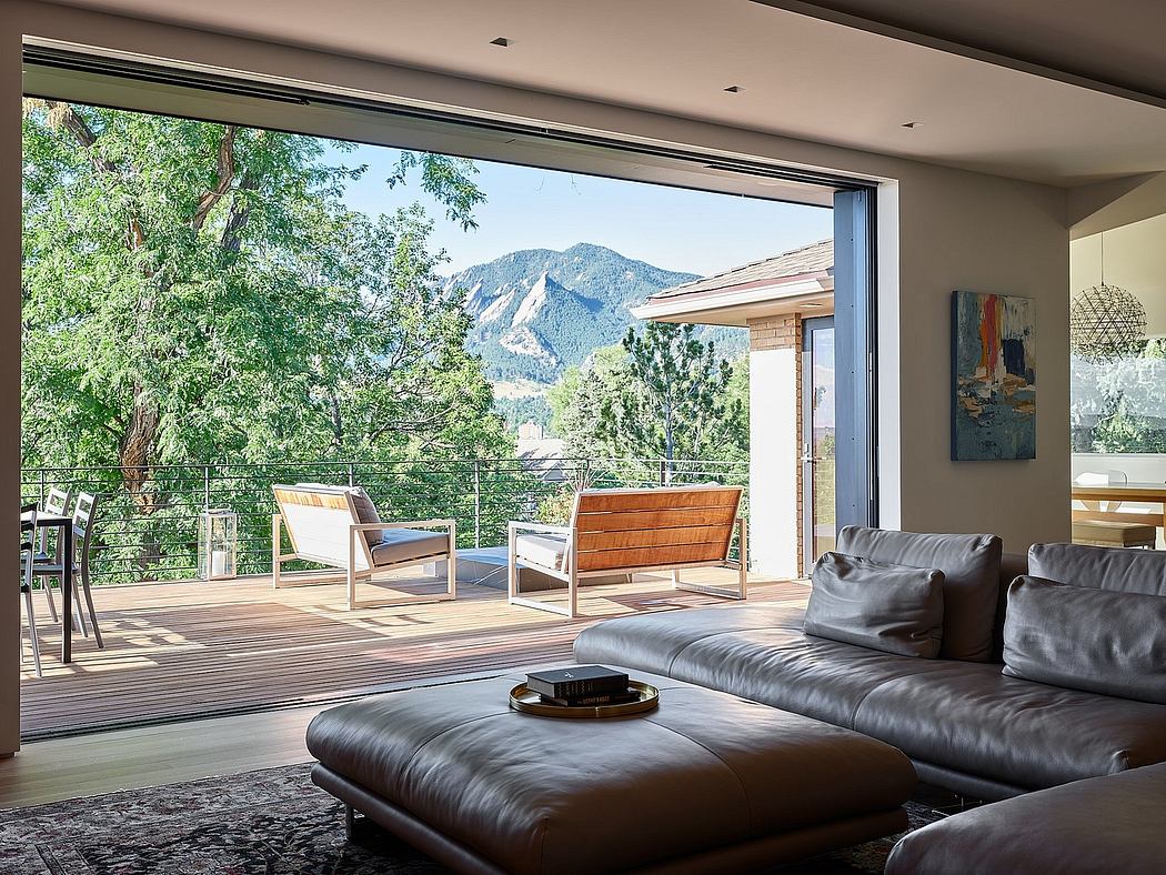 Expansive mountain views framed by sleek indoor-outdoor living space with modern furnishings.