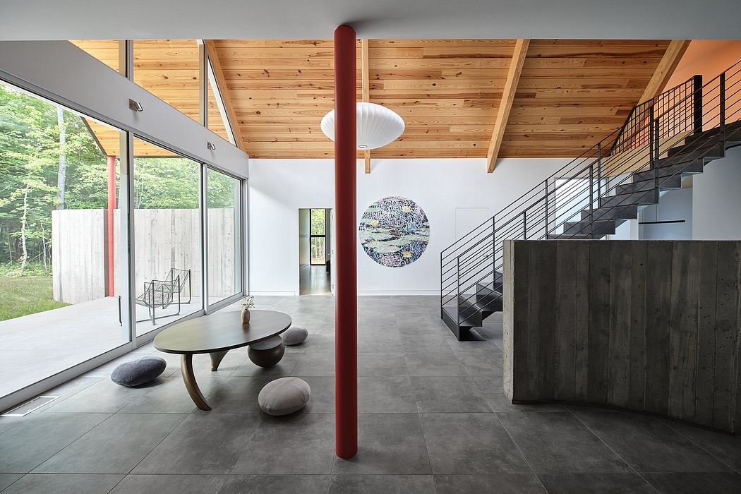 A modern, minimalist interior with a wooden ceiling, concrete flooring, and a sculptural coffee table.