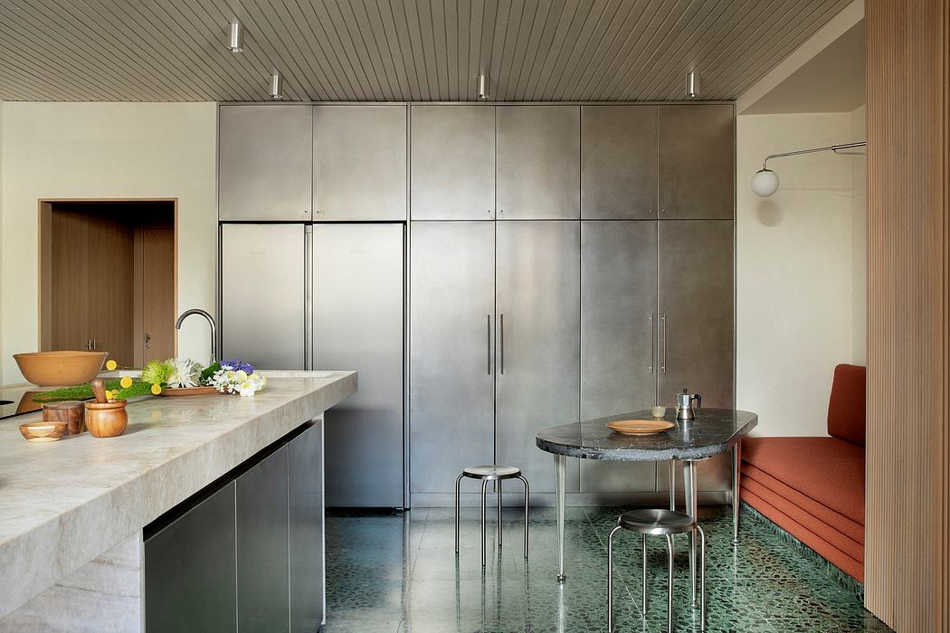 Sleek, modern kitchen with stainless steel appliances, marble counters, and patterned tile floor.