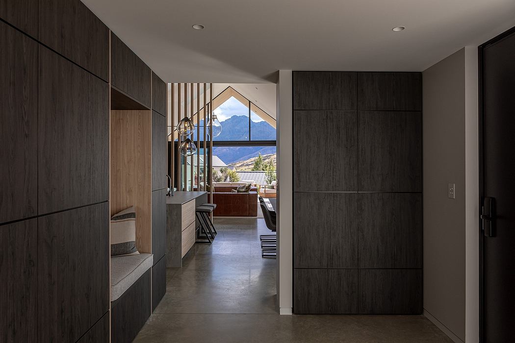 A modern, minimalist interior with dark wood cabinetry, highlighting a scenic view through a large window.
