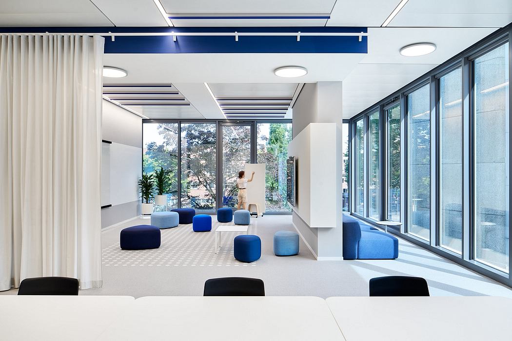 Large, bright corporate office with minimalist design featuring blue accents.