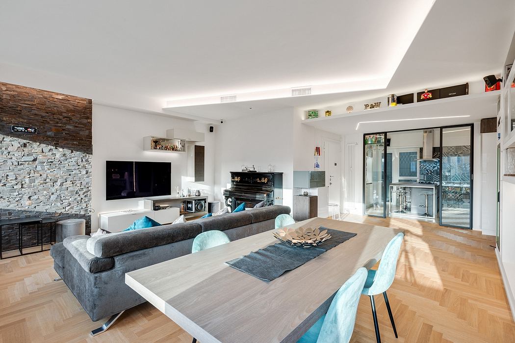 Spacious open-plan living room with modern furniture, stone accent wall, and wood floors.