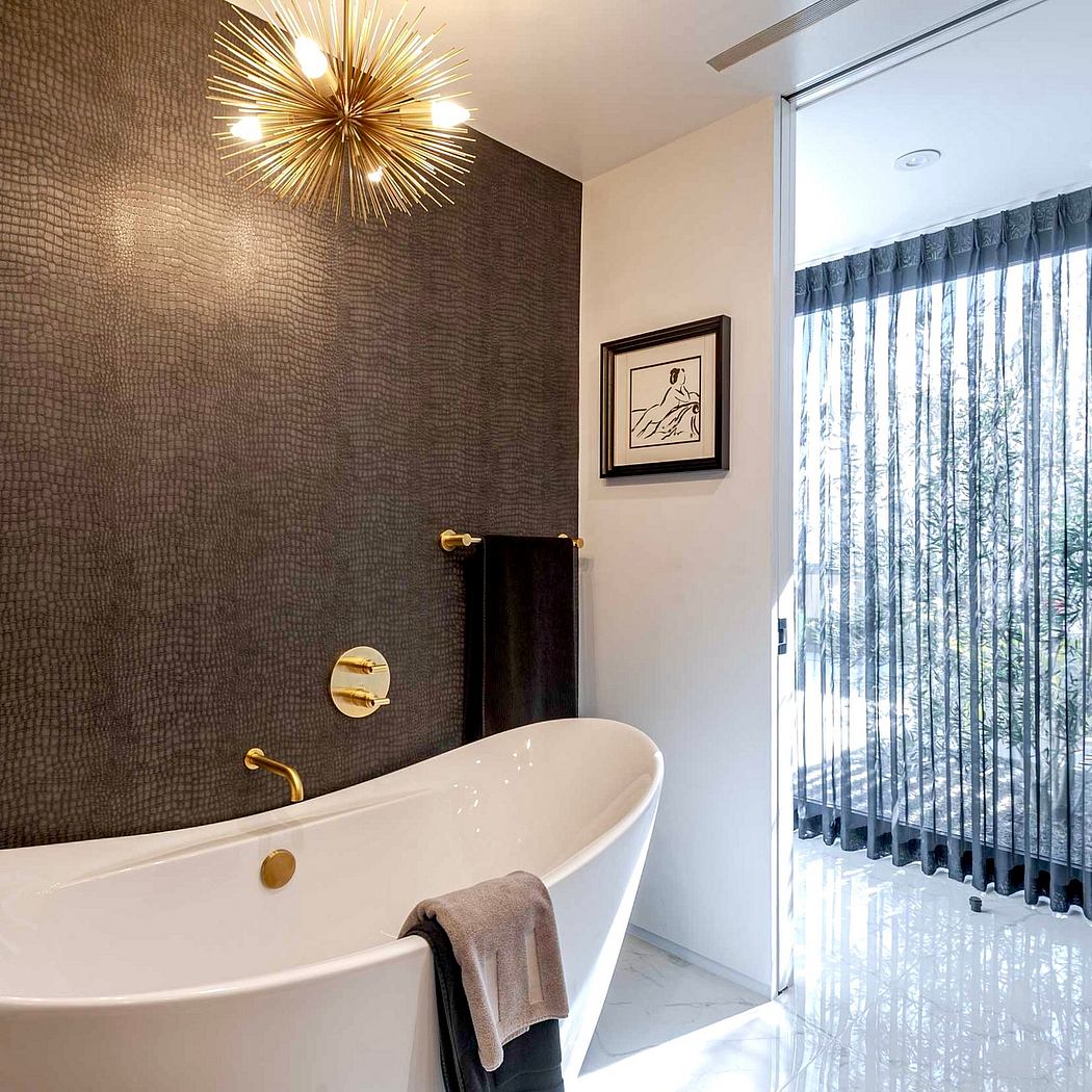 Luxurious bathroom with contemporary gold fixtures, freestanding tub, and patterned wall.