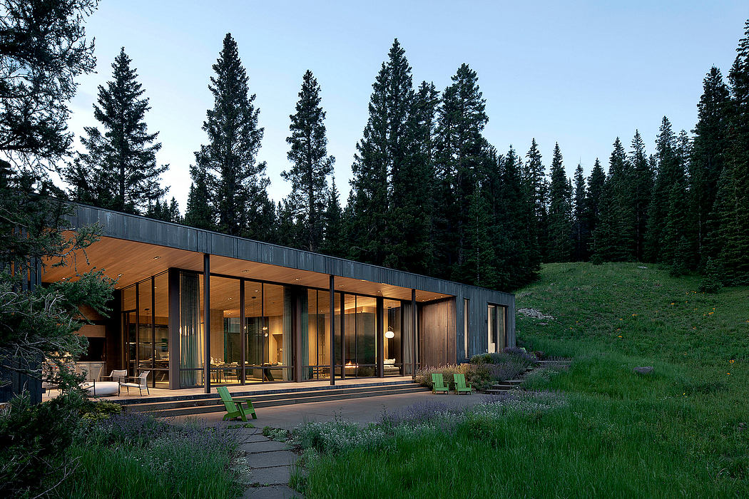 Sleek and modern cabin nestled in a lush, forested setting with large windows and wooden accents.