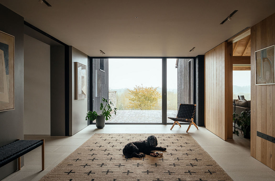 Sleek, modern interior with large windows, natural wood accents, and a cozy rug.