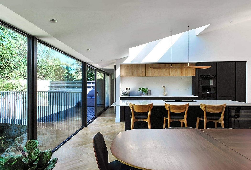 Open-concept kitchen with wooden cabinetry, island, and dining area overlooking a deck.