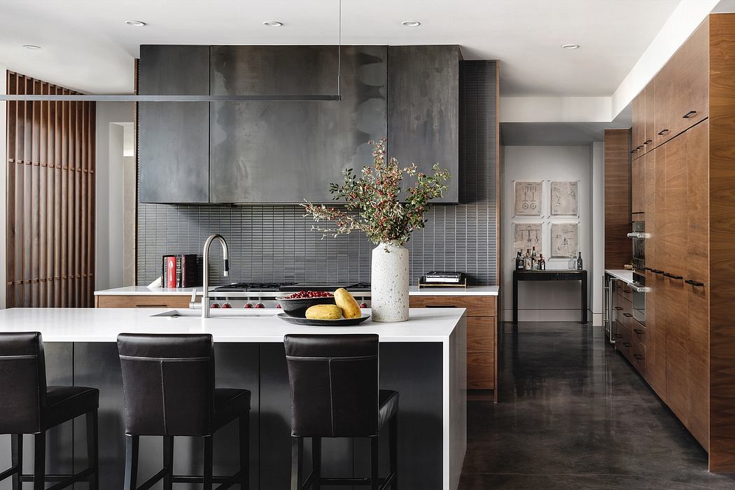 Modern kitchen with sleek black cabinetry, wood accents, and a striking floral centerpiece.