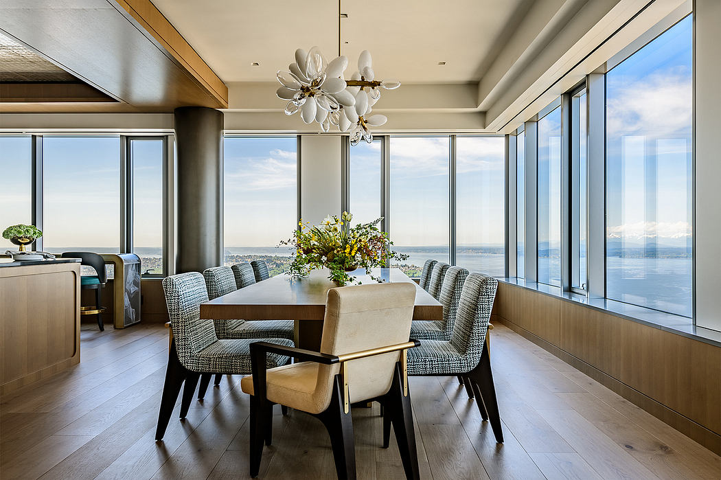 Elegant dining room with expansive views, modern chandelier, and plush seating.