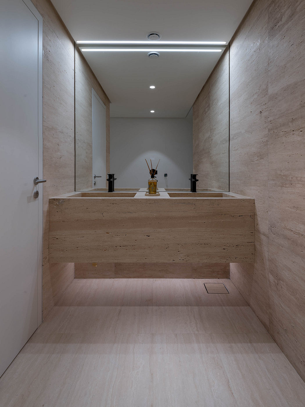 A minimalist bathroom design with a custom floating vanity and recessed lighting.