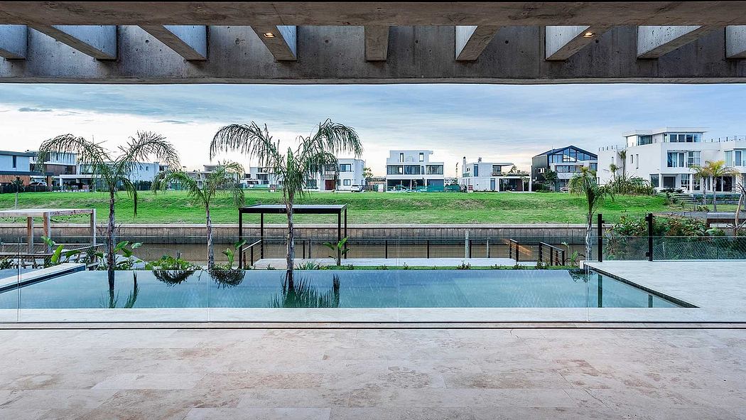 A modern outdoor pool surrounded by sleek architecture and lush palm trees.