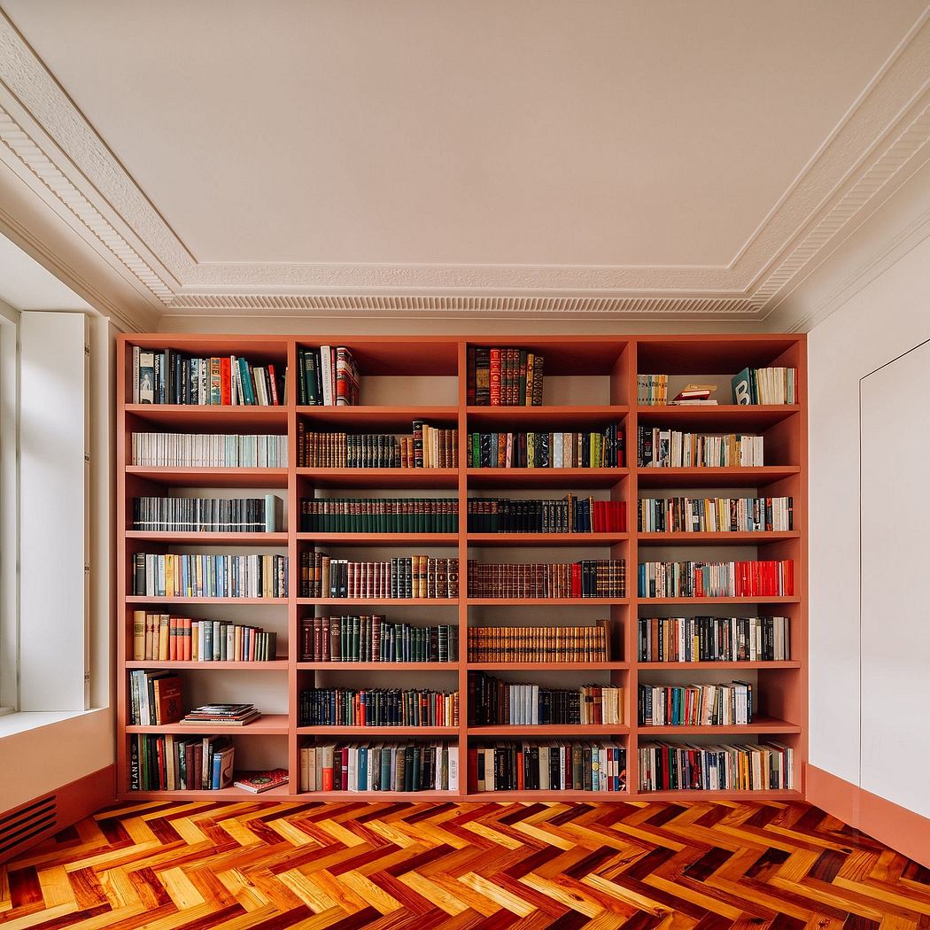 Ornate ceiling molding, floor-to-ceiling bookshelves with numerous volumes, herringbone parquet flooring.