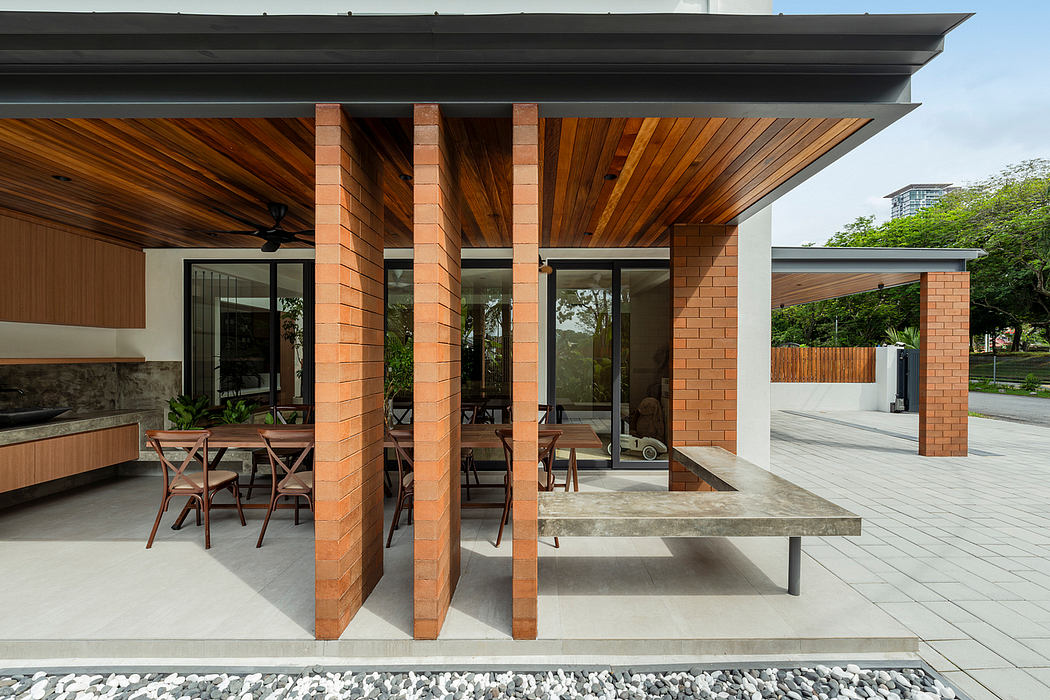 Sleek modern architecture featuring brick columns, wood paneling, and an outdoor dining area.