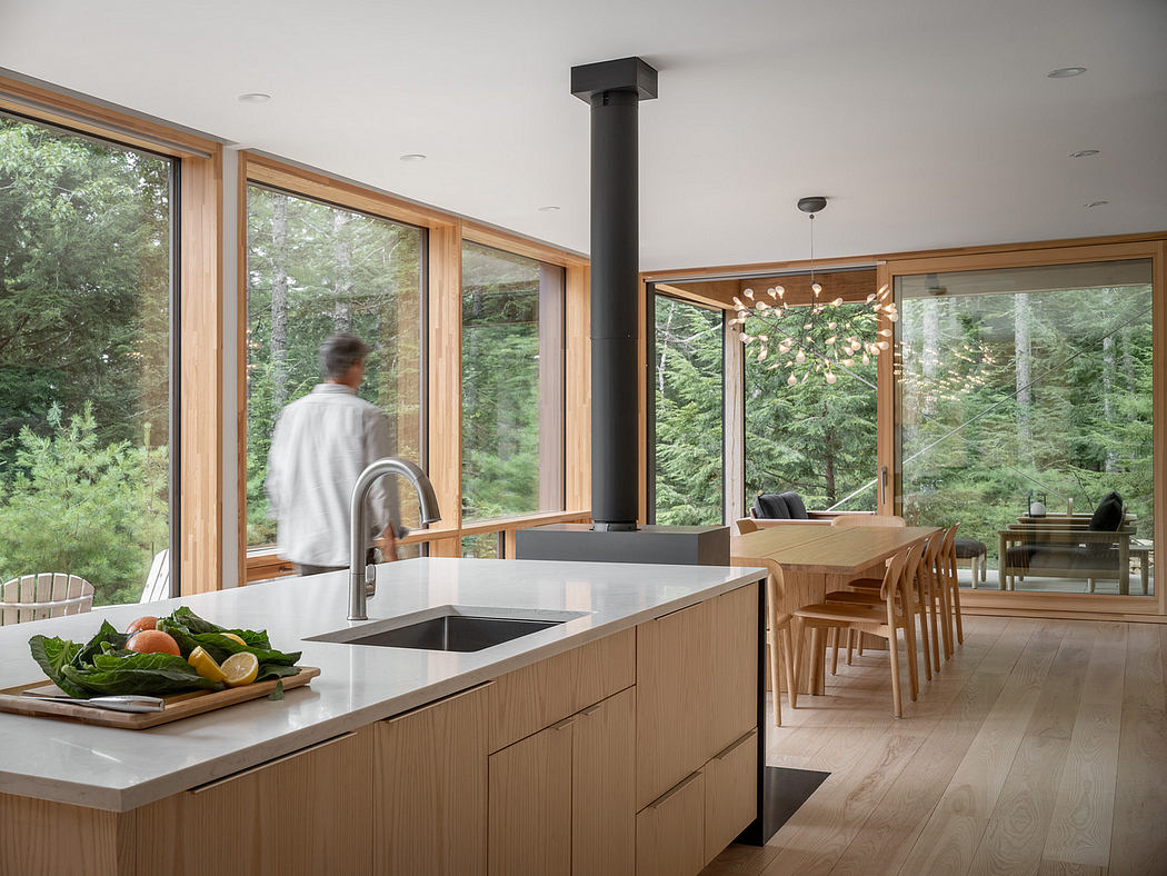 Bright, airy kitchen with minimalist wood and stone design elements, overlooking nature.