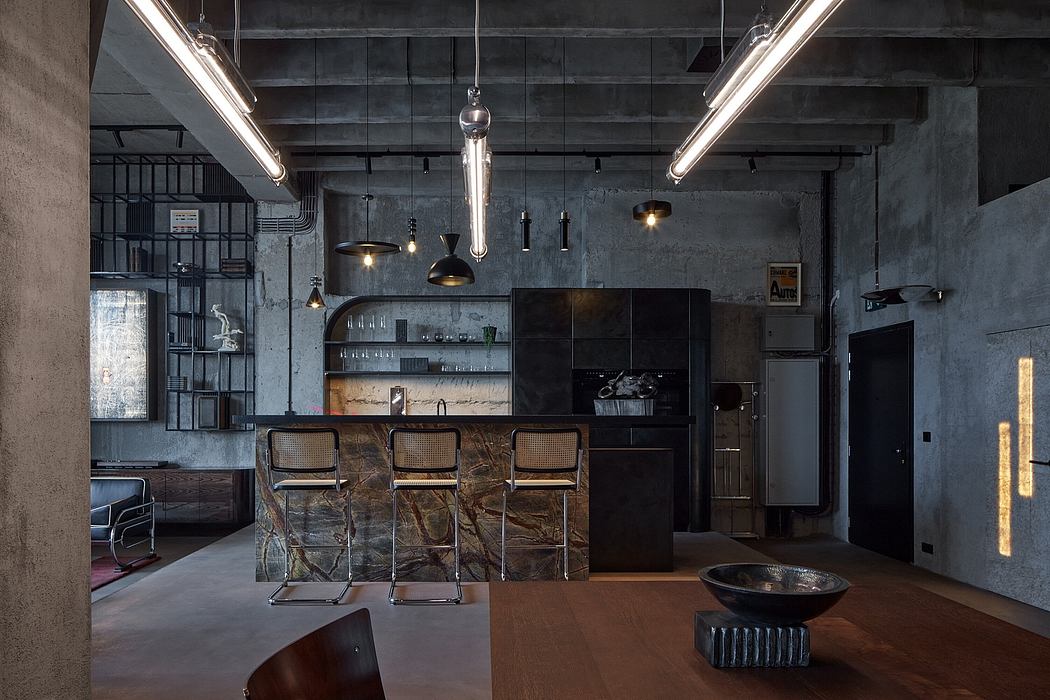 A modern, industrial-style kitchen with dark concrete walls, recessed lighting, and a marble-topped bar.
