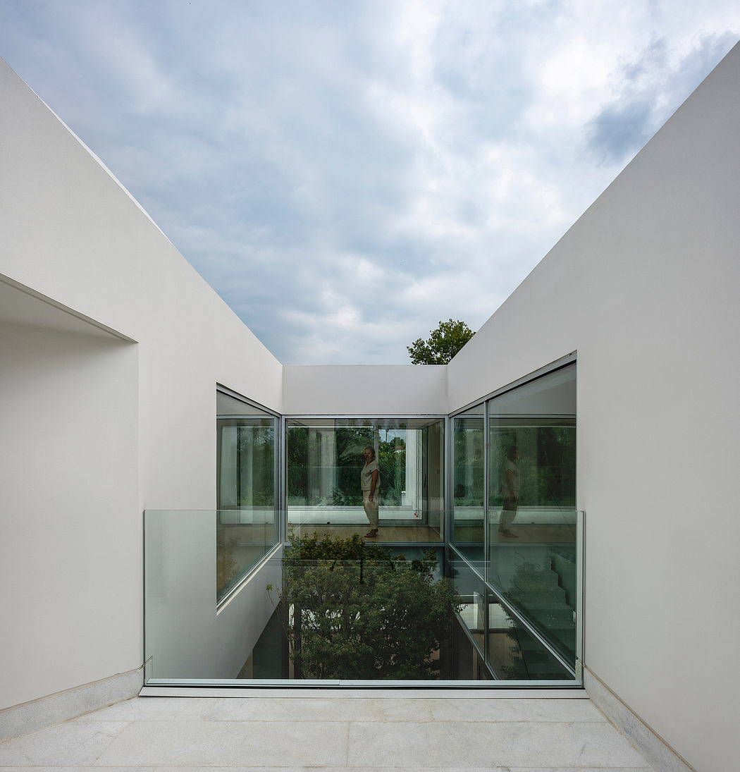 A modern, minimalist architectural design with expansive glass walls and a skylight.