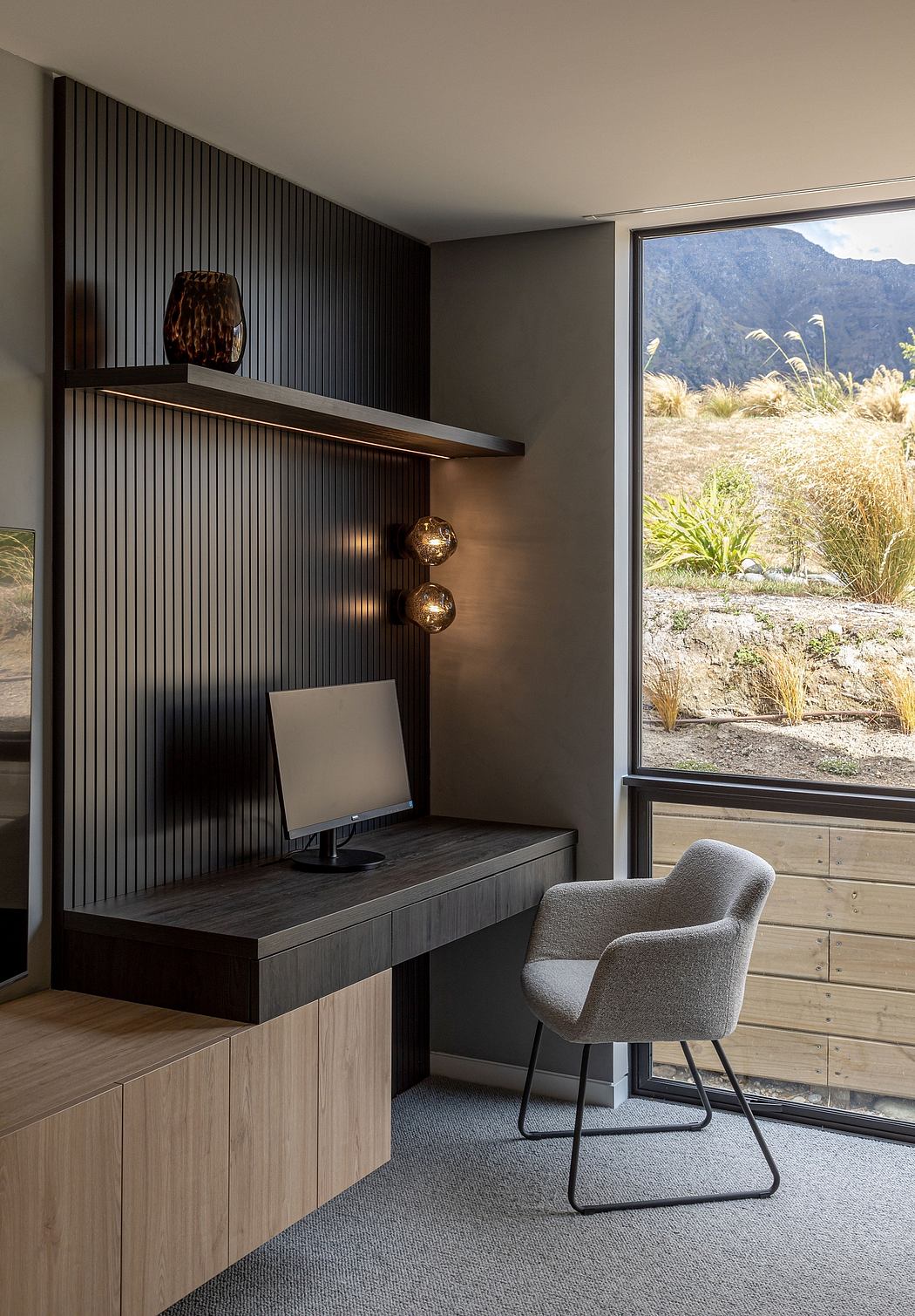 The image showcases a modern and minimalist home office space with a large window overlooking a scenic outdoor landscape.