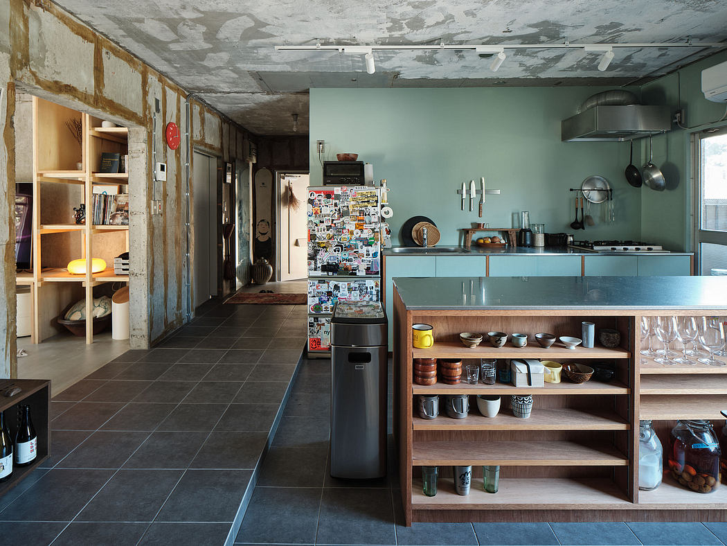 A rustic and eclectic kitchen space with exposed brick walls, sleek cabinets, and a stylish shelving unit.