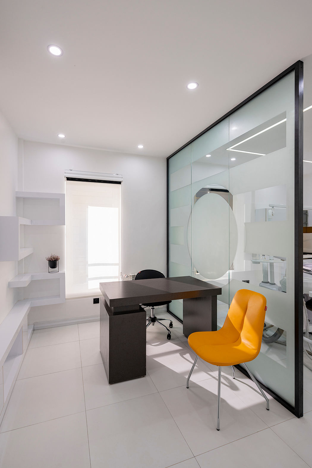 Sleek modern office with minimalist black desk, yellow chair, and full-length glass wall.