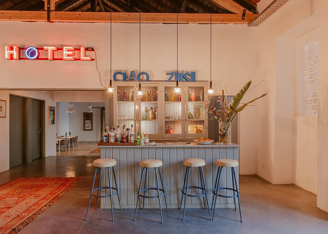 Rustic hotel bar with exposed beams, neon sign, and industrial metal bar stools.