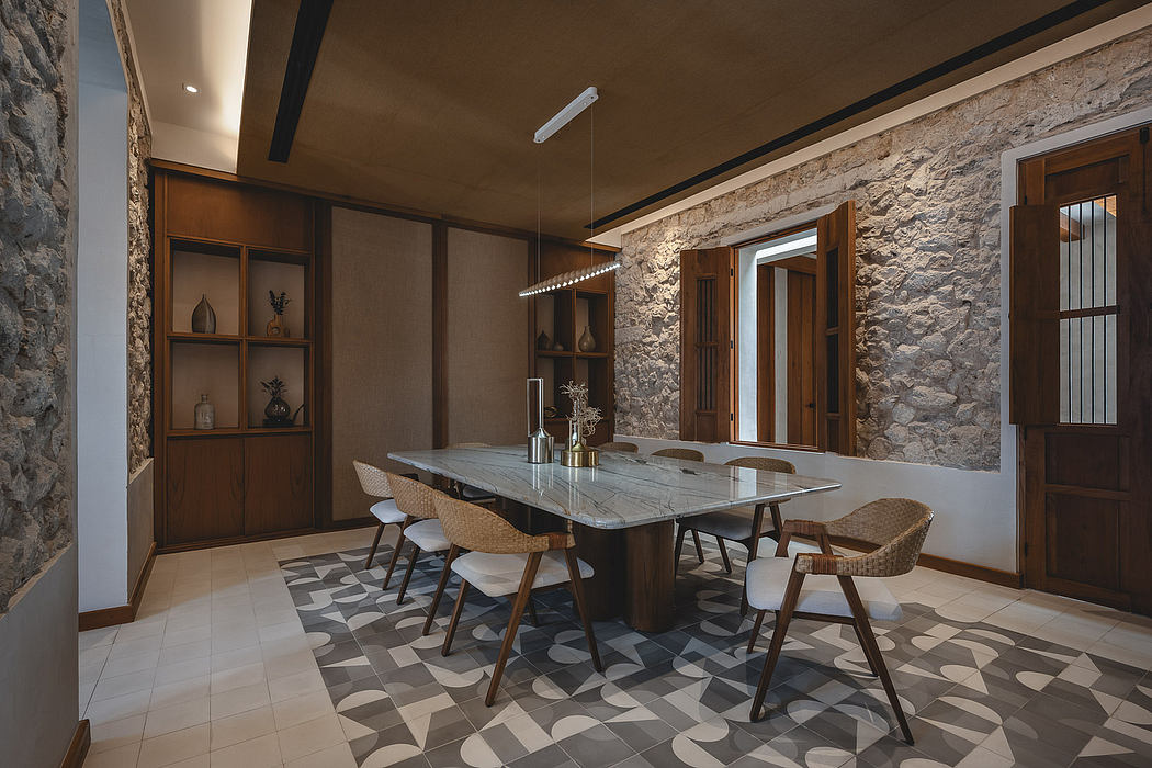 Rustic stone walls, modern wood furnishings, and geometric floor tiles create a warm, inviting space.