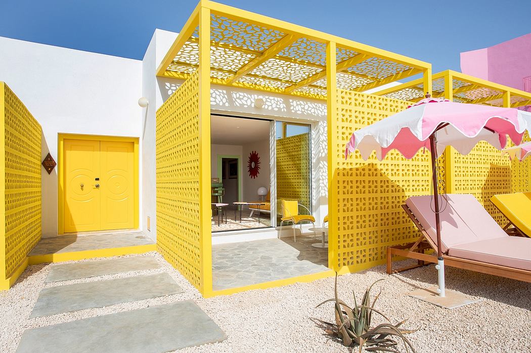 Vibrant yellow geometric pavilion with perforated screen walls, pink accents.