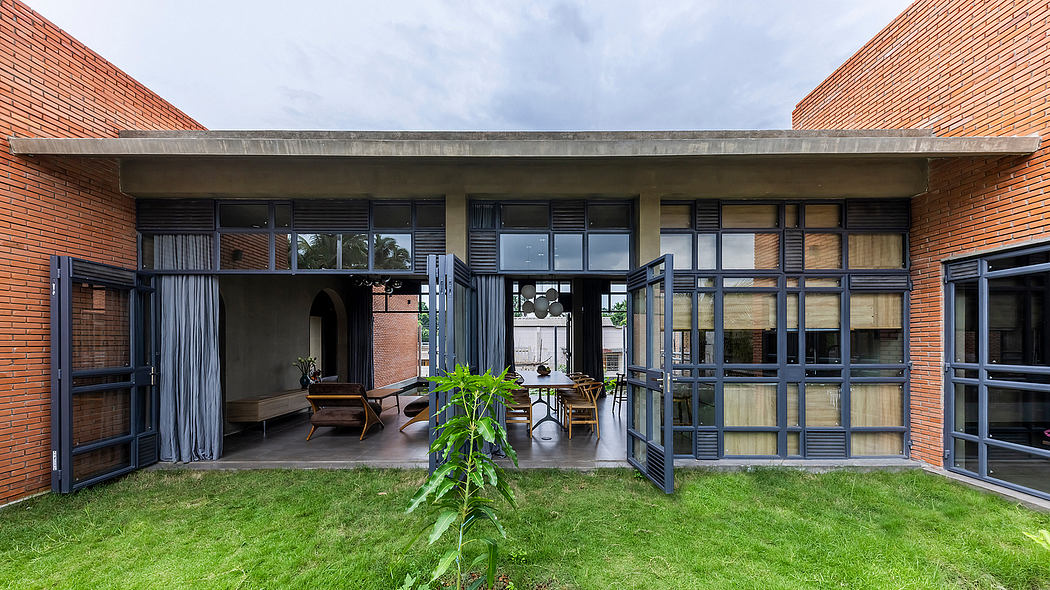 Minimalist brick exterior with expansive glass windows, metal framing, and lush greenery.