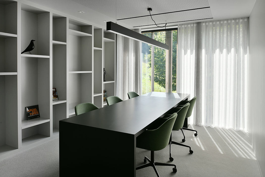 A modern, minimalist office space with built-in shelving and a large conference table.