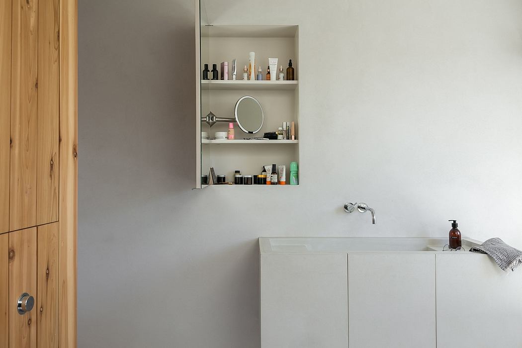 Spacious bathroom with modern white cabinetry, shelves displaying grooming products.