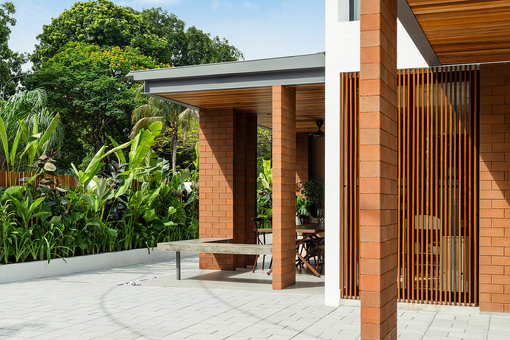 Modernist brick structure with wooden beams and tropical garden surroundings.