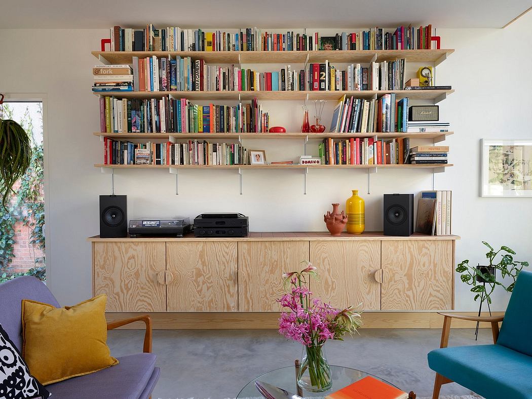Colorful, eclectic room with built-in shelving, media console, and vibrant furnishings.