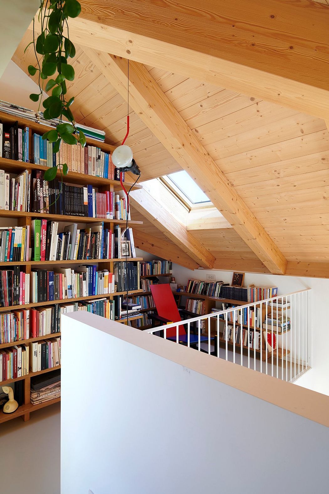 Cozy attic library with bookshelves lining the walls and a skylight window.