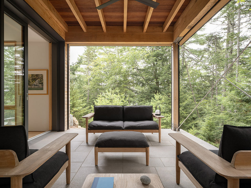 Modern cabin interior with wooden beams, large windows, and minimalist furniture.