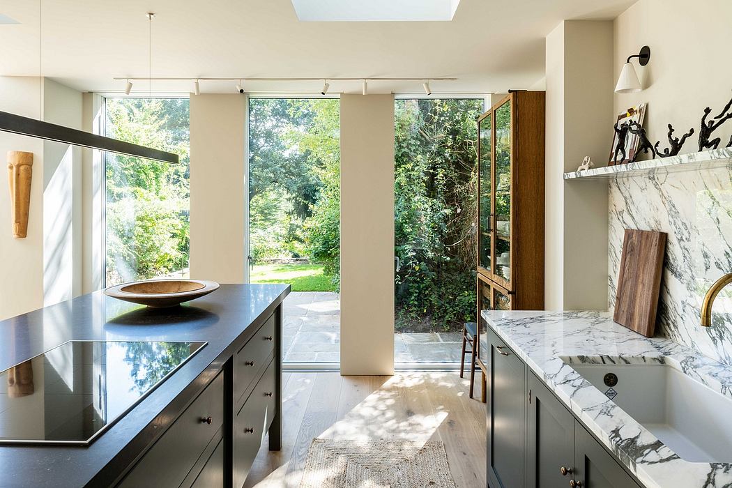 Spacious modern kitchen with expansive windows, marble countertops, and sleek cabinetry.