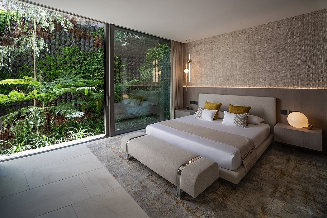 Cozy modern bedroom with floor-to-ceiling windows overlooking lush greenery.