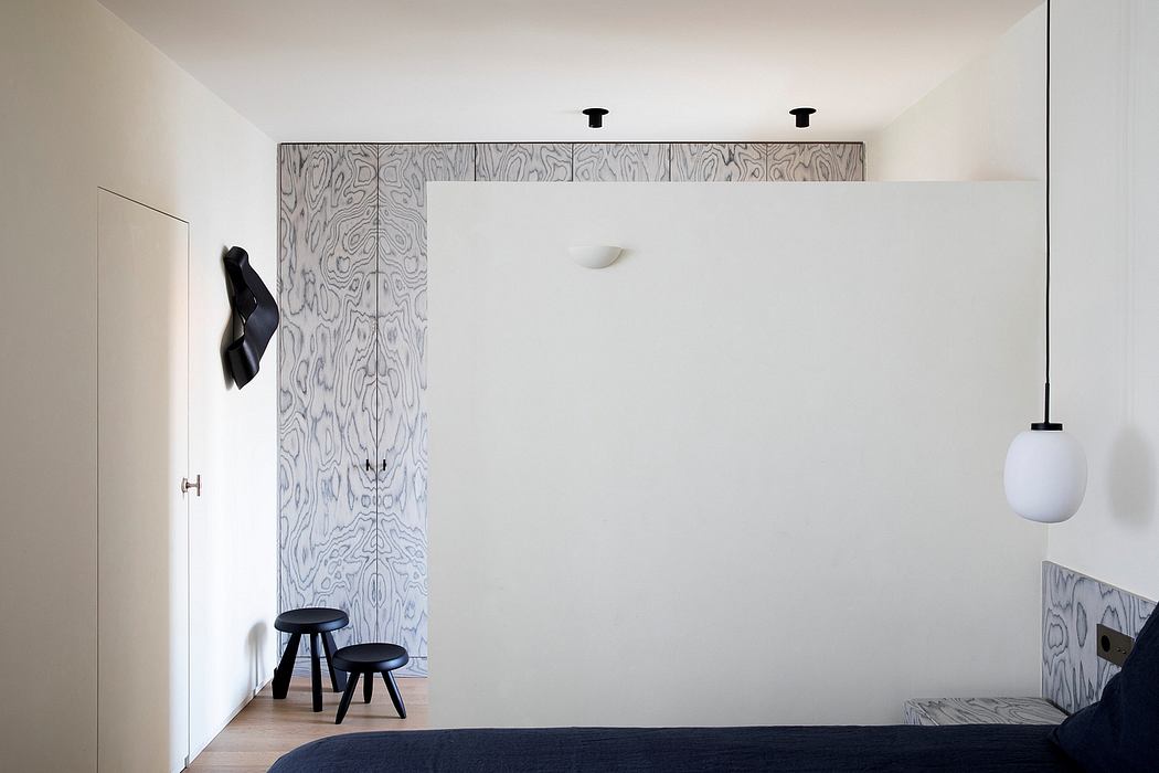Minimalist bedroom featuring clean lines, textured wood panels, and black furnishings.