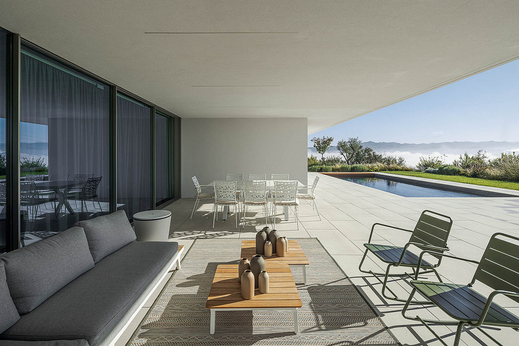 Sleek modern patio with pool, lounge furniture, and panoramic mountain views.