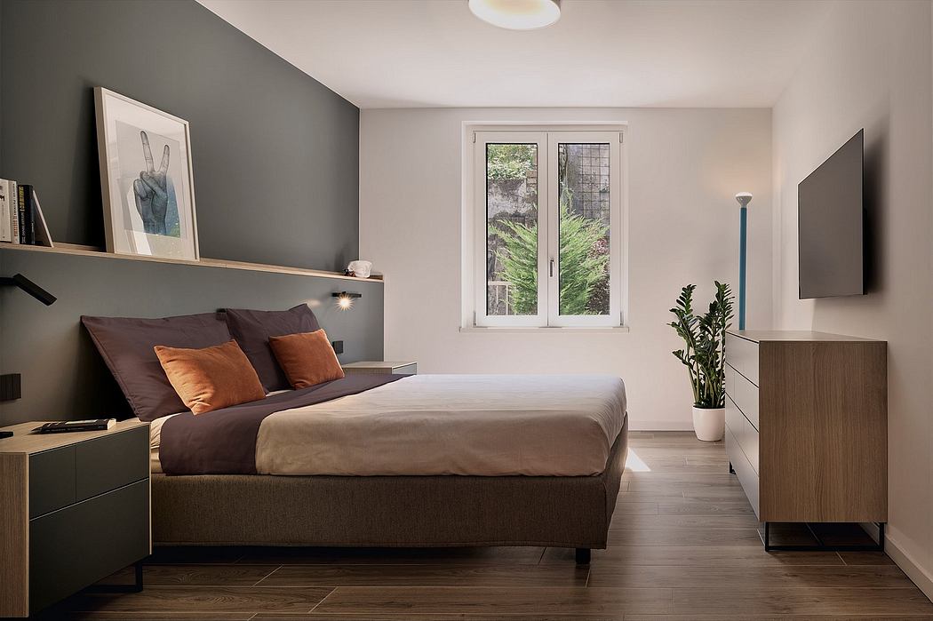 Cozy bedroom with modern furnishings, large window overlooking lush greenery, and sleek design elements.