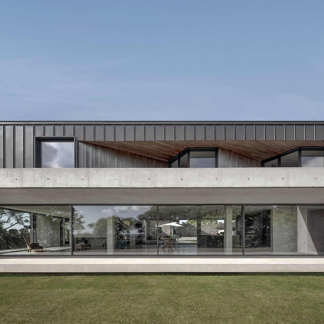 Contemporary architecture with wooden accents, floor-to-ceiling windows, and an expansive terrace overlooking a lush lawn.