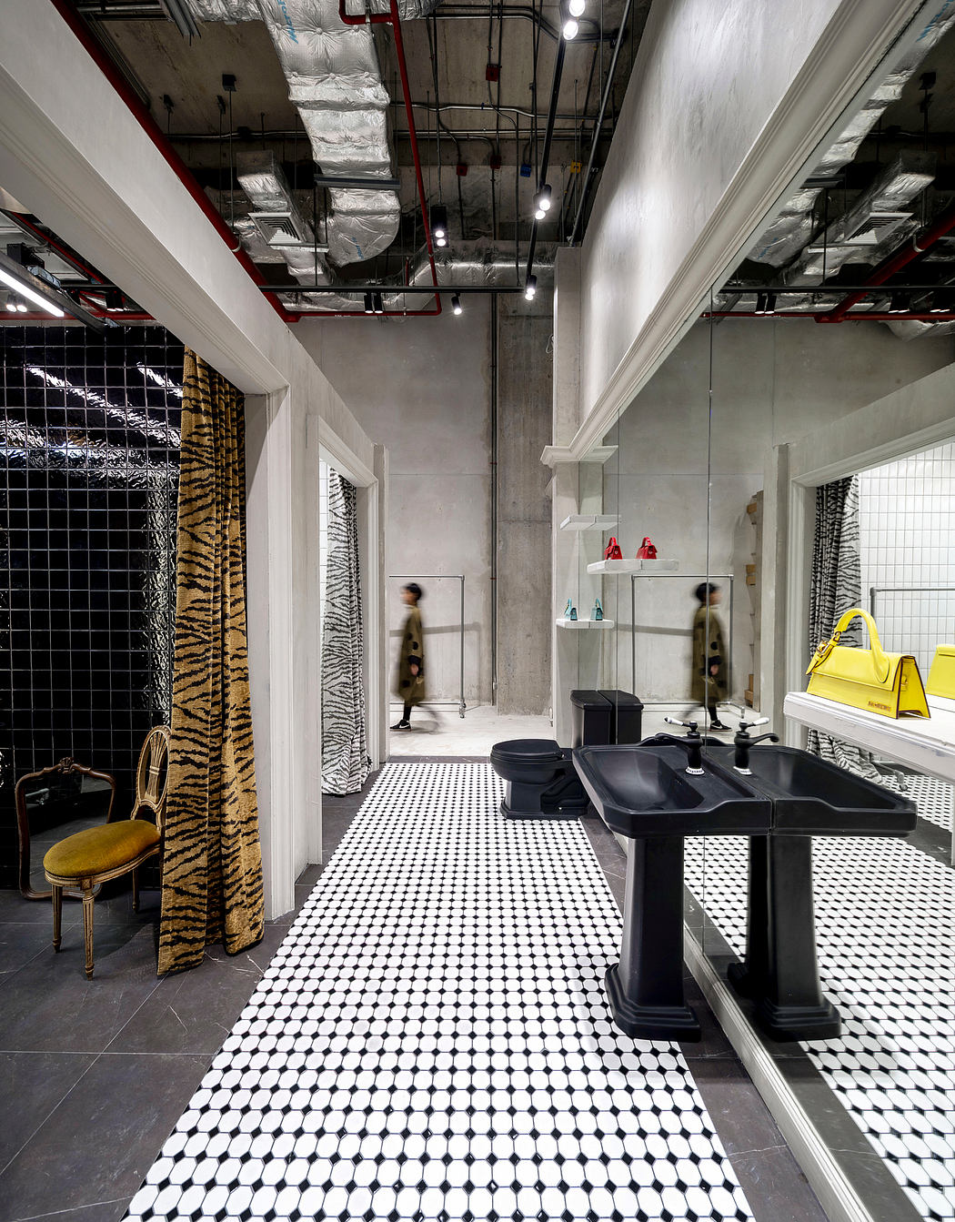Dramatic industrial-style bathroom with bold monochrome tile, shelves, and fixtures.